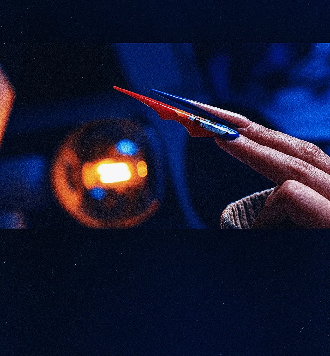Blue and red student nail work shown from a side angle